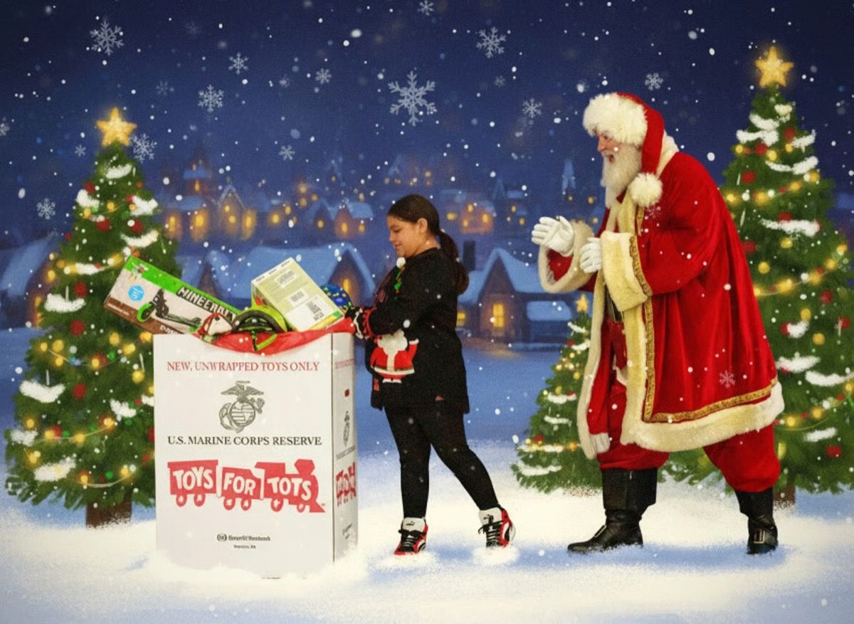 Santa Glenn cheering as a young girl drops a gift into a Toys for Tots donation box