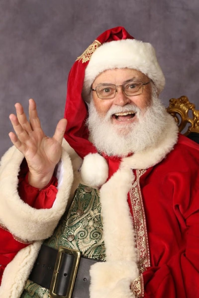 Santa Glenn waving while seated in an ornate chair