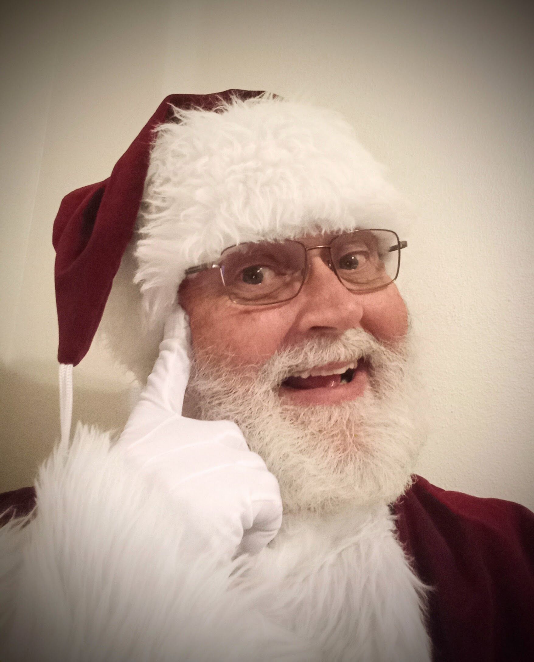 Santa Glenn smiling and laying a finger beside his nose